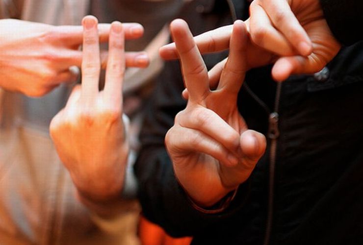Duas pessoas fazendo o sinal de sustenido - cerquilha - com as mãos ilustra este artigo sobre: 'Como criar uma Hashtag''.